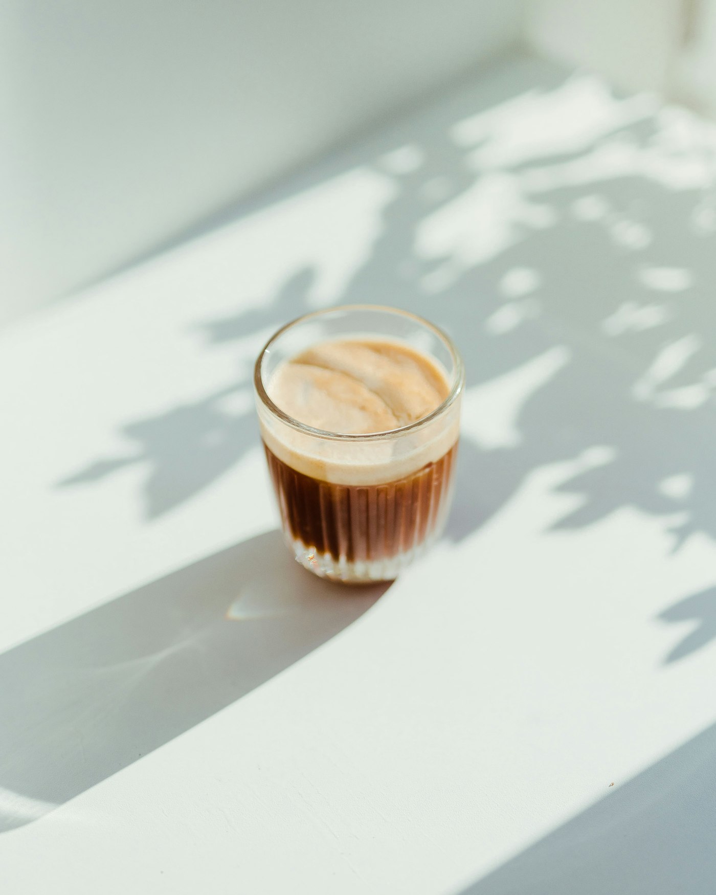 A glass of freshly brewed coffee in soft natural light